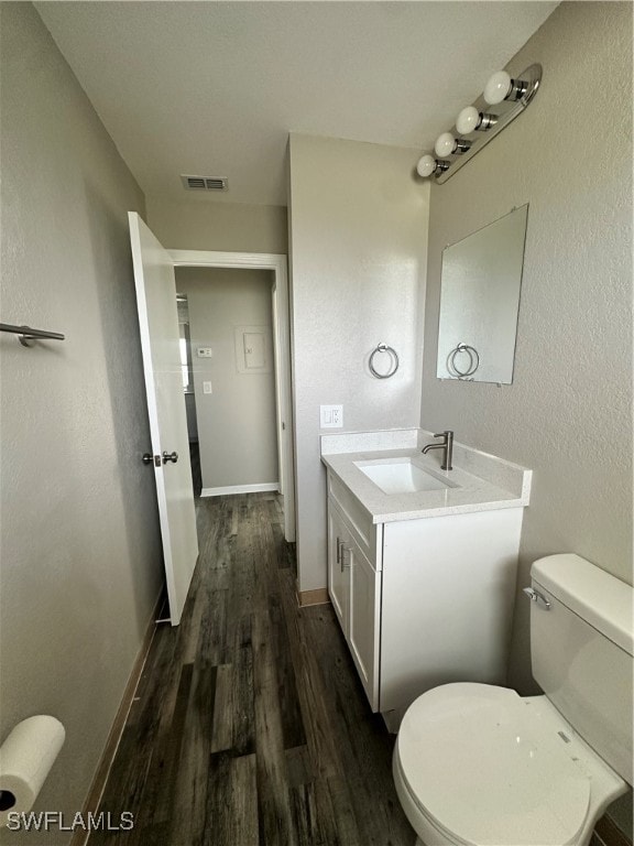 bathroom featuring vanity, hardwood / wood-style floors, and toilet