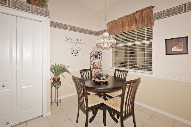 tiled dining room featuring an inviting chandelier