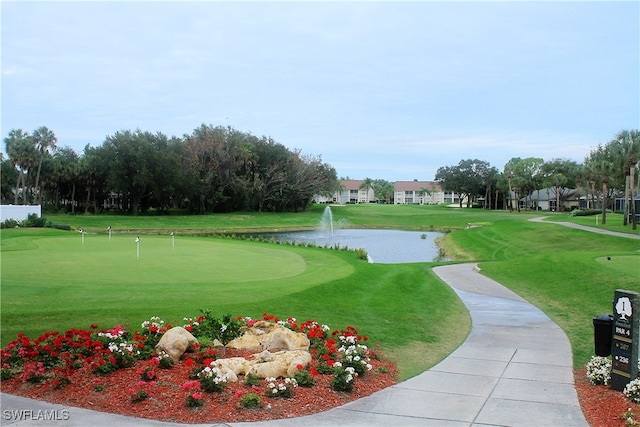 surrounding community featuring a lawn and a water view