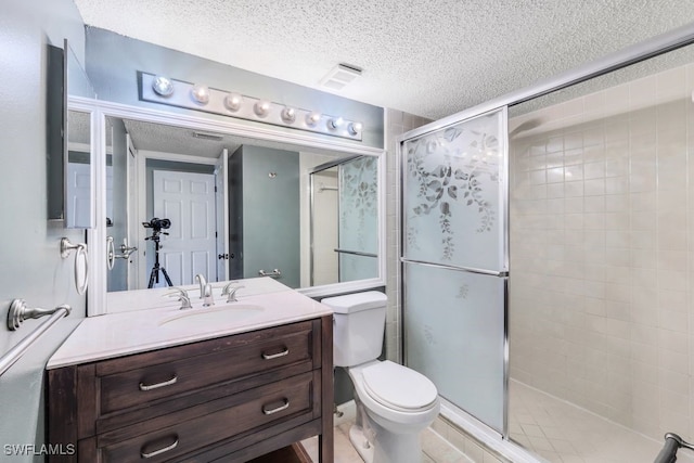 bathroom with vanity, an enclosed shower, a textured ceiling, and toilet