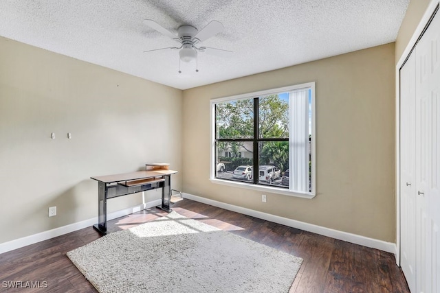 office space with dark wood-type flooring, ceiling fan, and a textured ceiling