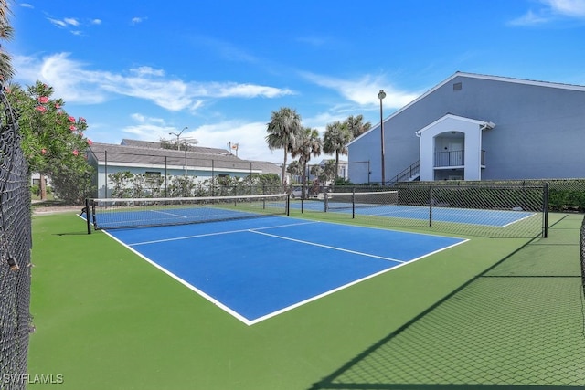 view of tennis court featuring fence