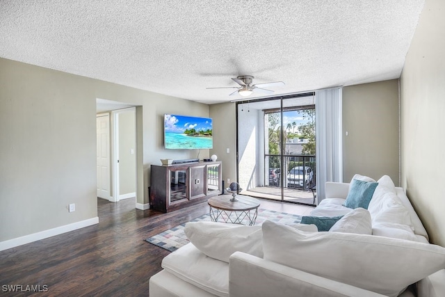 living room with ceiling fan, a textured ceiling, baseboards, and wood finished floors