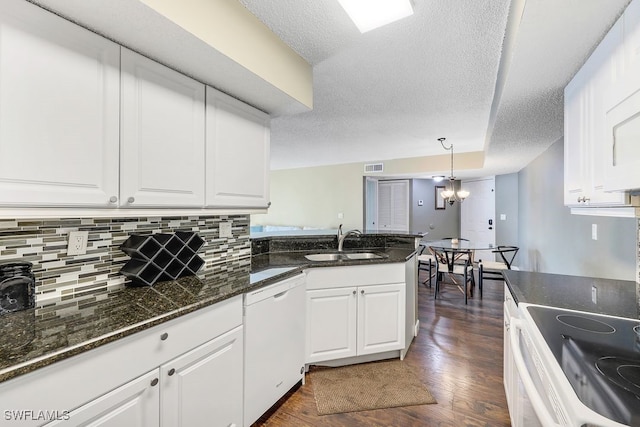 kitchen featuring a peninsula, white dishwasher, dark wood-style floors, white cabinets, and a sink