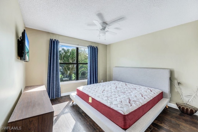 bedroom with baseboards, a textured ceiling, wood finished floors, and a ceiling fan