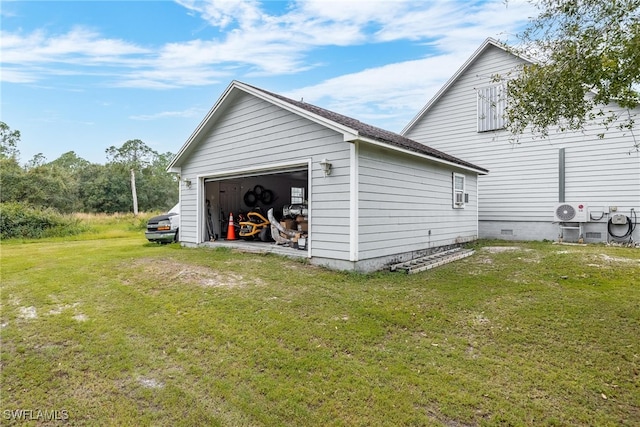 view of property exterior featuring cooling unit, an outbuilding, a garage, and a lawn