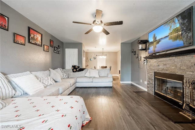 living room featuring a fireplace, dark hardwood / wood-style floors, and ceiling fan