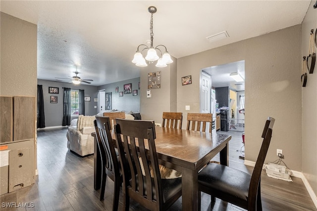 dining area featuring a textured ceiling, dark wood-type flooring, and ceiling fan with notable chandelier