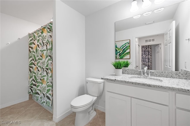 bathroom featuring vanity, toilet, and tile patterned flooring