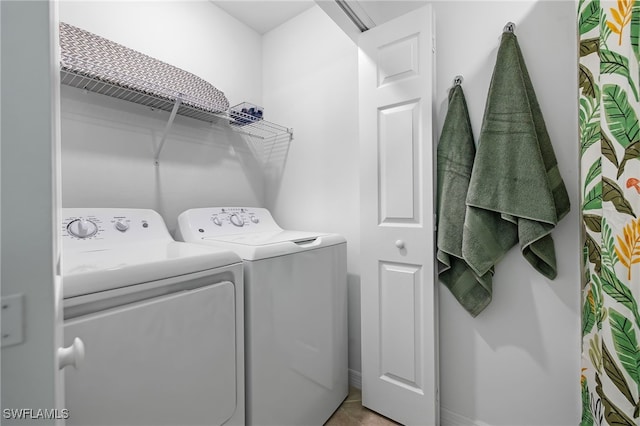 washroom featuring light tile patterned flooring and washing machine and clothes dryer