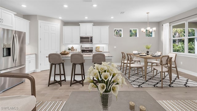 kitchen featuring white cabinets, stainless steel appliances, and light wood-type flooring