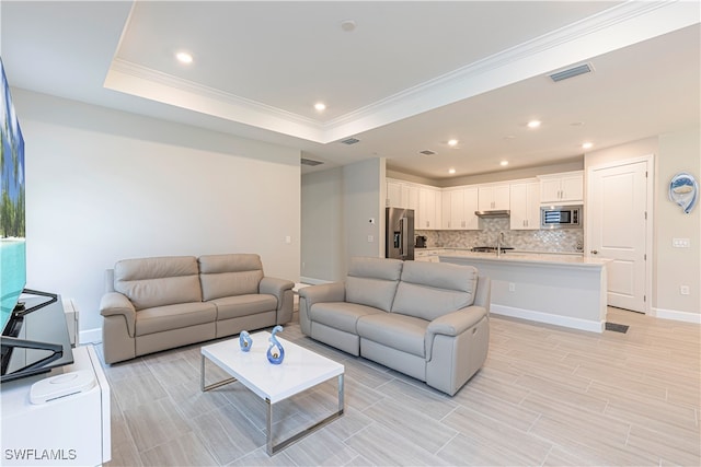 living room featuring crown molding and a tray ceiling