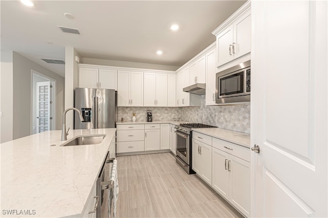 kitchen with appliances with stainless steel finishes, sink, and white cabinets