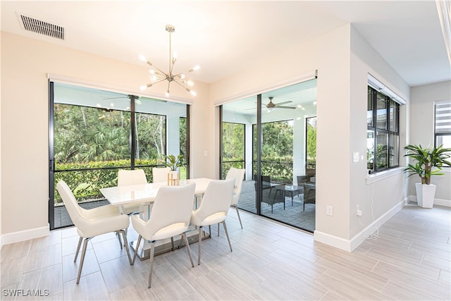 dining room with light hardwood / wood-style flooring, ceiling fan with notable chandelier, and a wealth of natural light