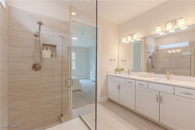 bathroom featuring vanity, a healthy amount of sunlight, and a shower with door