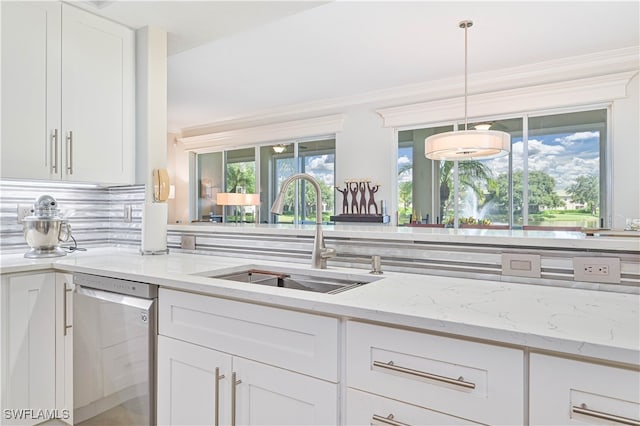 kitchen with sink, light stone countertops, decorative light fixtures, stainless steel dishwasher, and white cabinetry