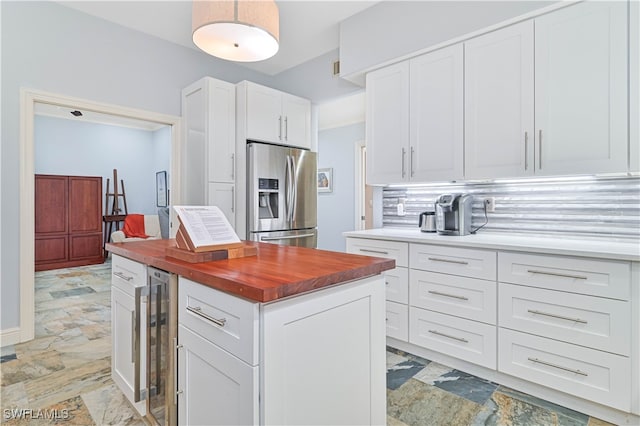 kitchen with white cabinetry, decorative backsplash, stainless steel refrigerator with ice dispenser, and beverage cooler