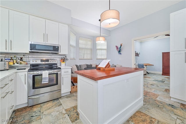 kitchen featuring white cabinetry, backsplash, appliances with stainless steel finishes, and decorative light fixtures