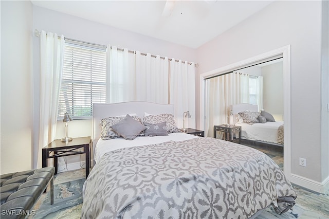 bedroom with multiple windows, a closet, and ceiling fan