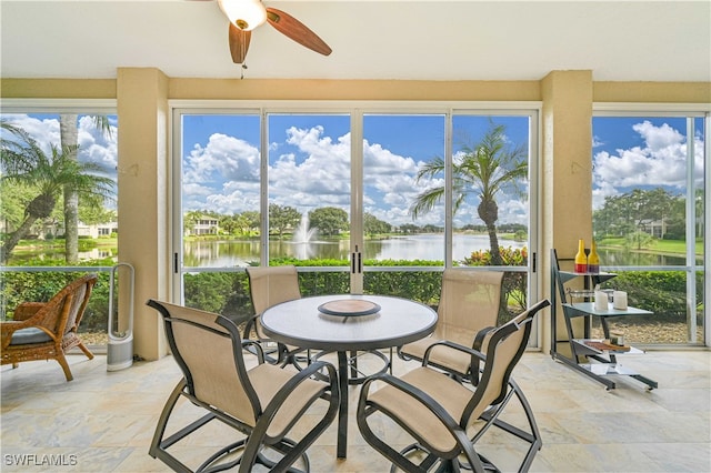 sunroom featuring a water view and ceiling fan