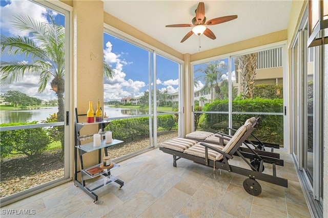 sunroom featuring ceiling fan, a water view, and plenty of natural light