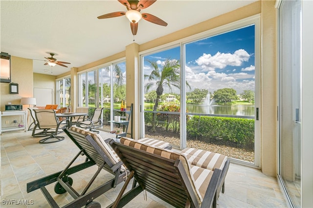 sunroom with ceiling fan, a water view, and a wealth of natural light