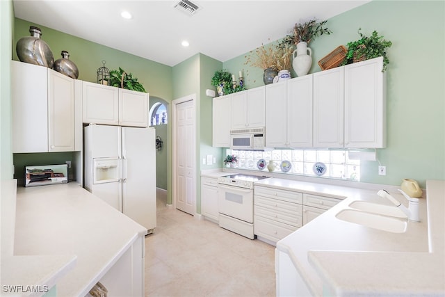 kitchen with white cabinetry, white appliances, and sink