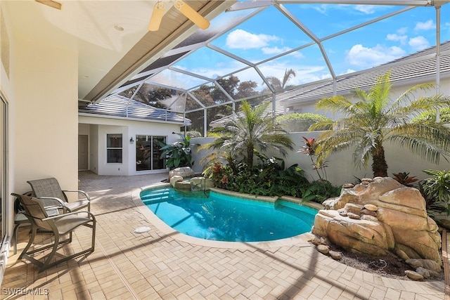 view of swimming pool featuring a lanai and a patio area