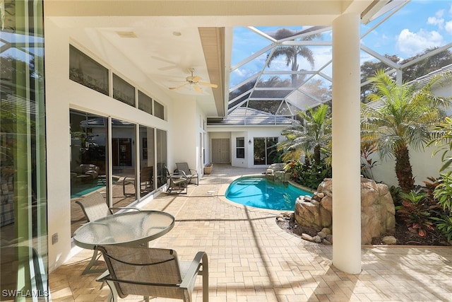 view of swimming pool with ceiling fan, a lanai, and a patio area