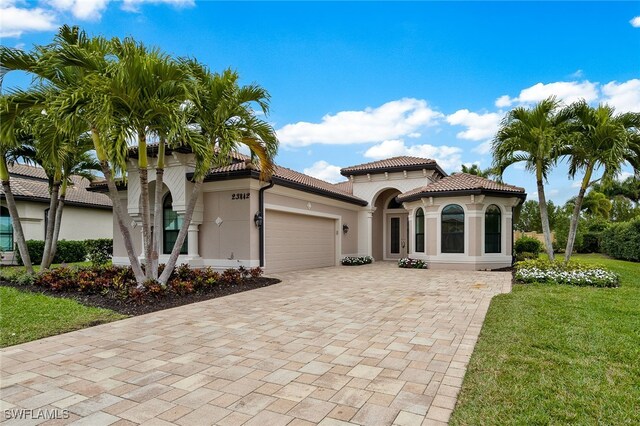 mediterranean / spanish-style house featuring a garage and a front yard