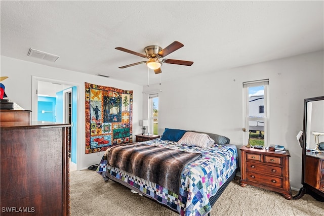 carpeted bedroom with a textured ceiling and ceiling fan