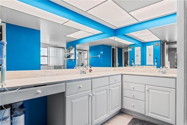 bathroom with vanity, a shower with shower door, and tile patterned floors