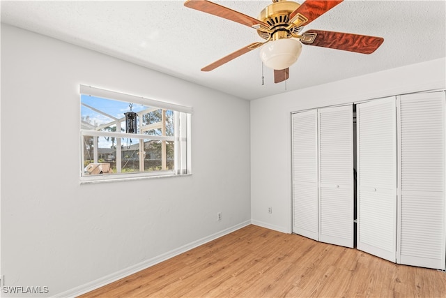 unfurnished bedroom with a closet, ceiling fan, a textured ceiling, and light wood-type flooring