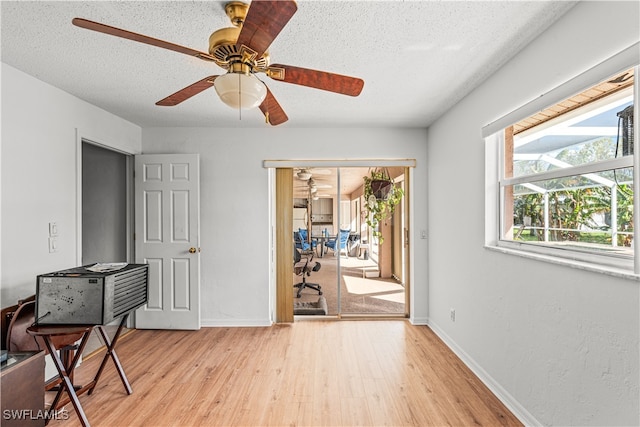 interior space featuring light hardwood / wood-style floors, a textured ceiling, and ceiling fan