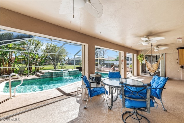 view of swimming pool featuring an in ground hot tub, ceiling fan, a patio, and a lanai