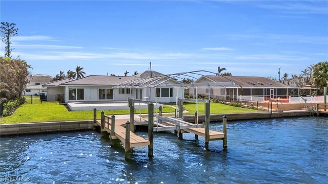 view of dock featuring a lanai, a yard, and a water view