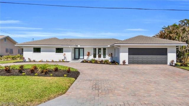 ranch-style house featuring a garage and a front yard