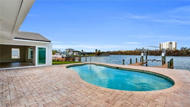 view of pool featuring a patio area, a water view, and a boat dock