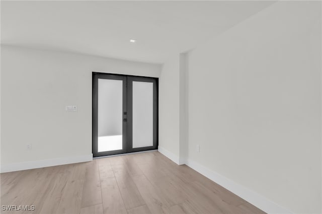 unfurnished room with light wood-type flooring and french doors