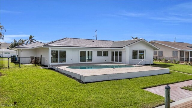 rear view of house featuring a patio, a fenced in pool, and a yard