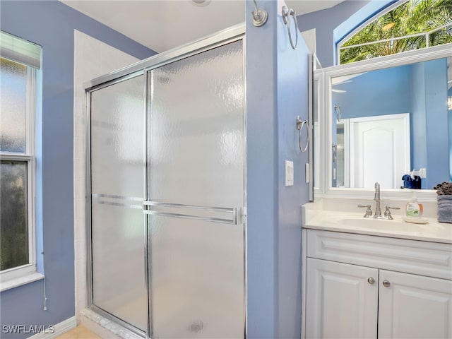 bathroom featuring vanity and a shower with shower door