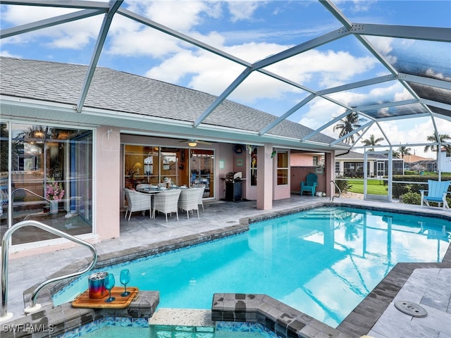 view of pool with a grill, glass enclosure, and a patio