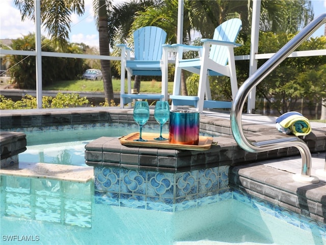 view of pool featuring a hot tub and a lanai