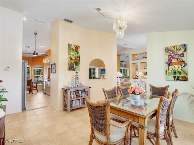 dining room featuring an inviting chandelier, vaulted ceiling, and light tile patterned floors