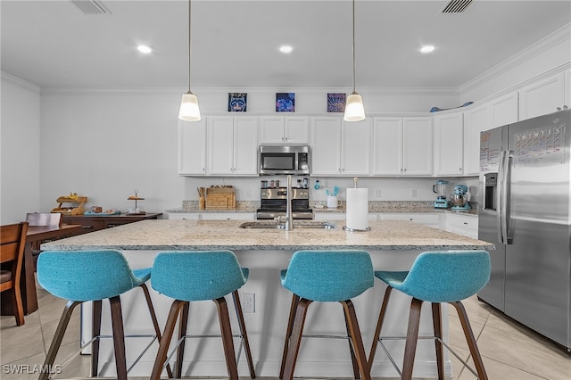 kitchen featuring white cabinets, a kitchen island with sink, and stainless steel appliances