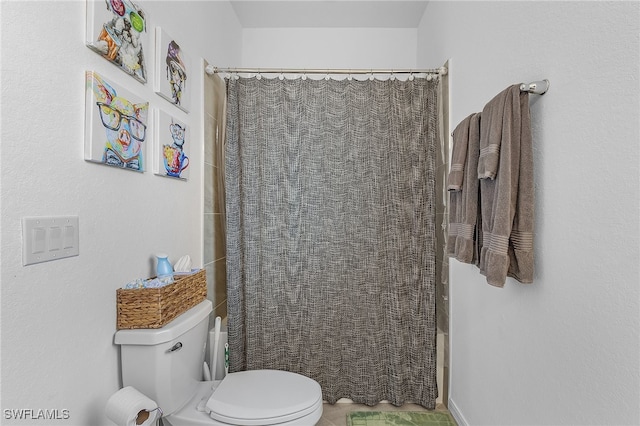 bathroom with toilet and a shower with shower curtain