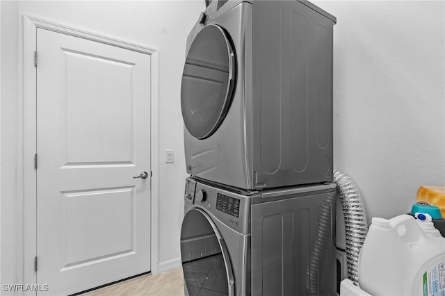 clothes washing area with stacked washer / dryer and light tile patterned floors