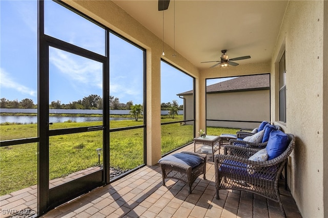 sunroom with a water view and ceiling fan