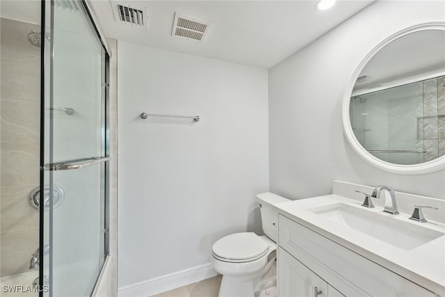 bathroom featuring vanity, toilet, and a shower with shower door