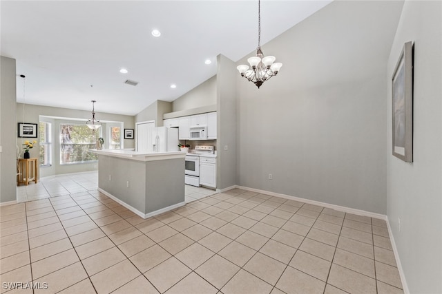 kitchen with white appliances, white cabinets, decorative light fixtures, and a center island